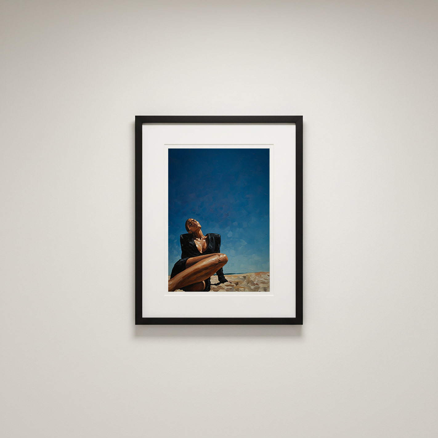 Framed photograph of a person sitting on a beach with a blue sky.