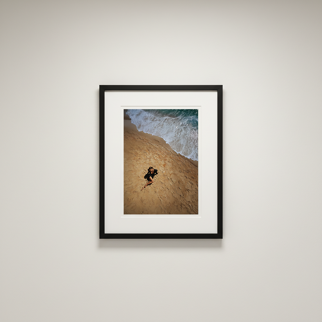 Framed photograph of a person on a beach with waves in the background