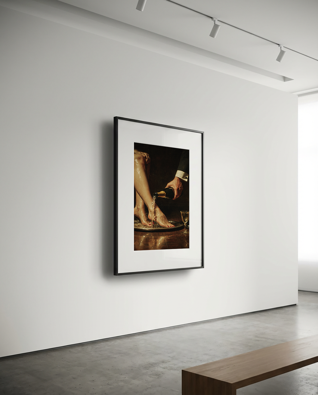 Framed artwork on a white wall in a minimalistic room with a wooden bench.