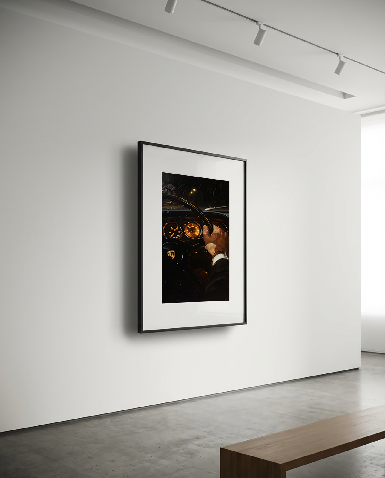 Framed artwork on a white wall in a minimalistic room with a wooden bench.