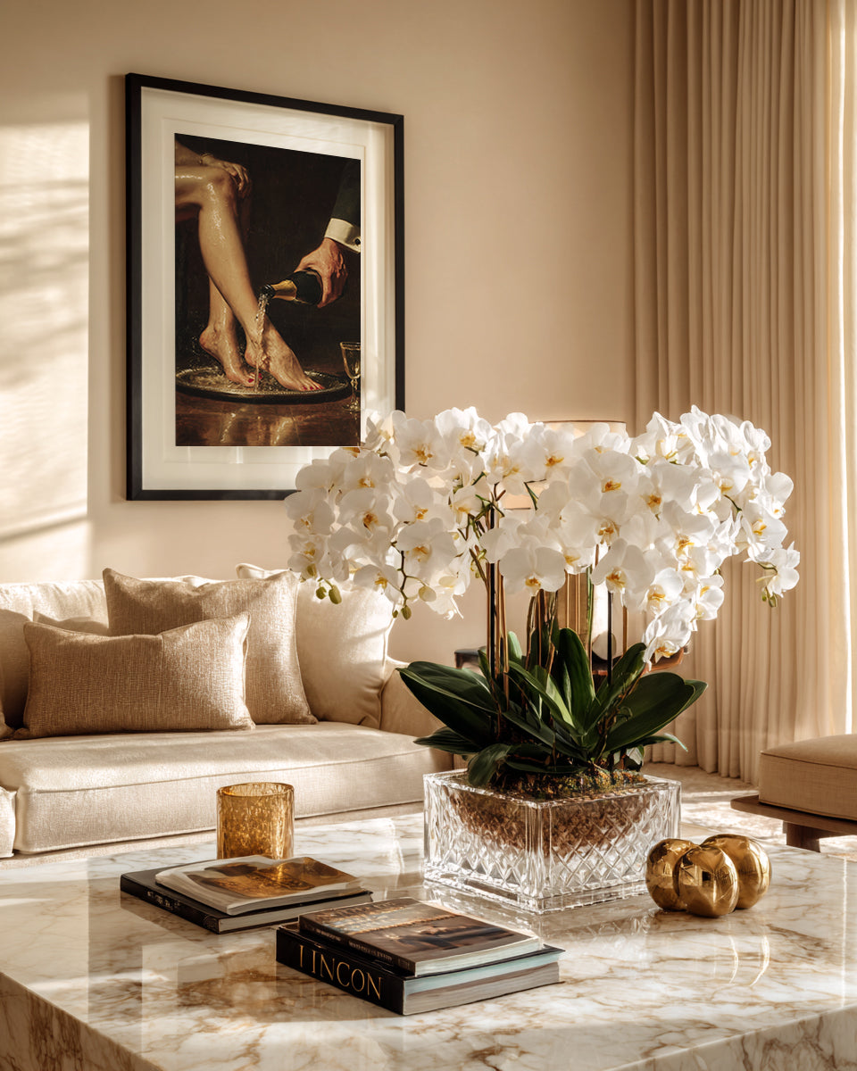 Living room with a marble coffee table, white orchids, and a framed painting on the wall.