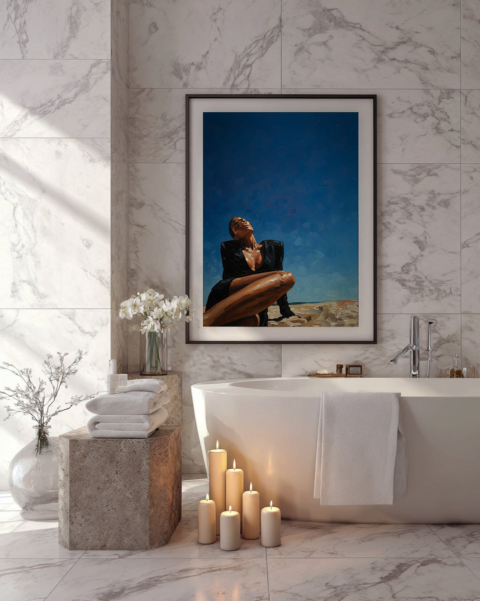 Bathroom with marble walls, a bathtub, candles, and a framed photograph of a couple on a beach.
