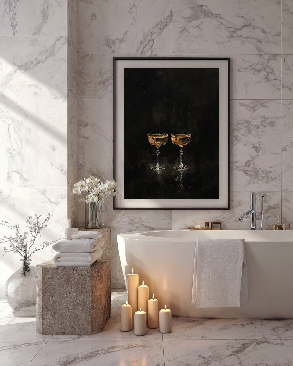 Bathroom with marble walls, bathtub, candles, and a framed photo of two glasses.