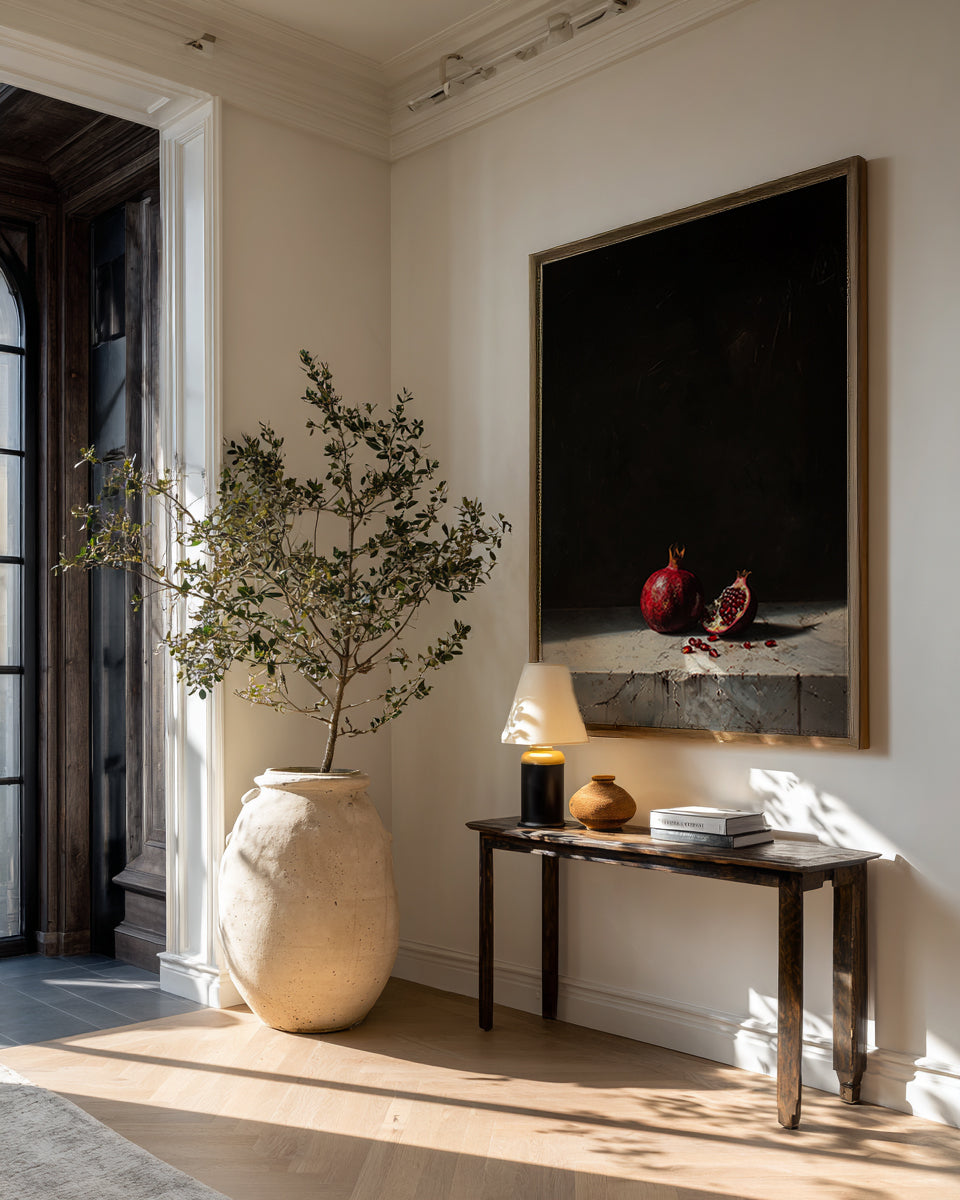 Modern interior with a vase, plant, and artwork on a wall.