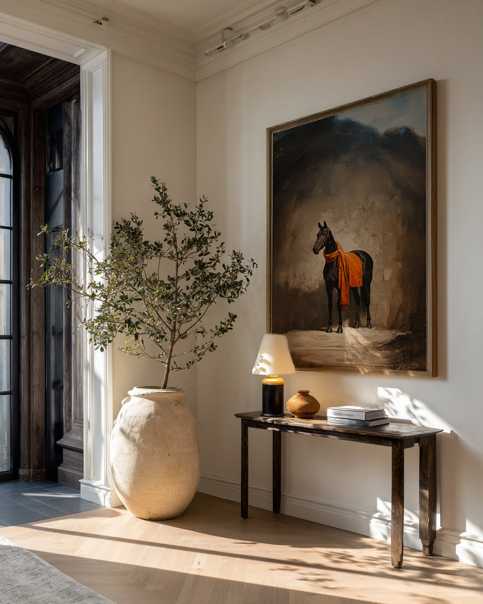 Room interior with a vase, lamp, and painting of a horse on a wall.