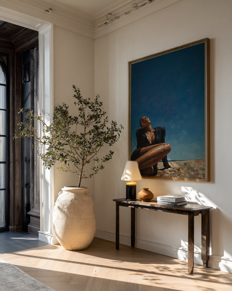 Modern interior with a vase, lamp, and artwork on a wall.