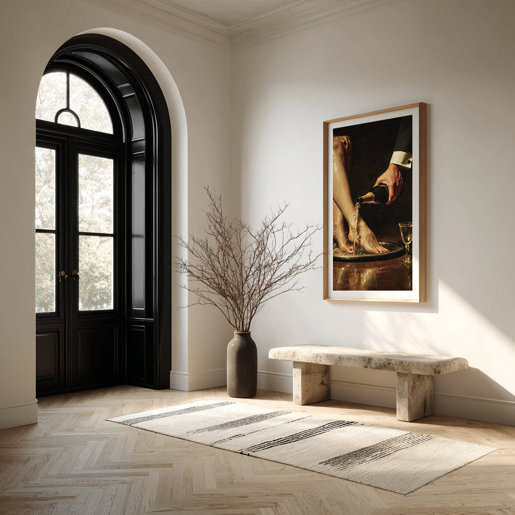Elegant interior with a black door, marble bench, and framed artwork on a white wall.
