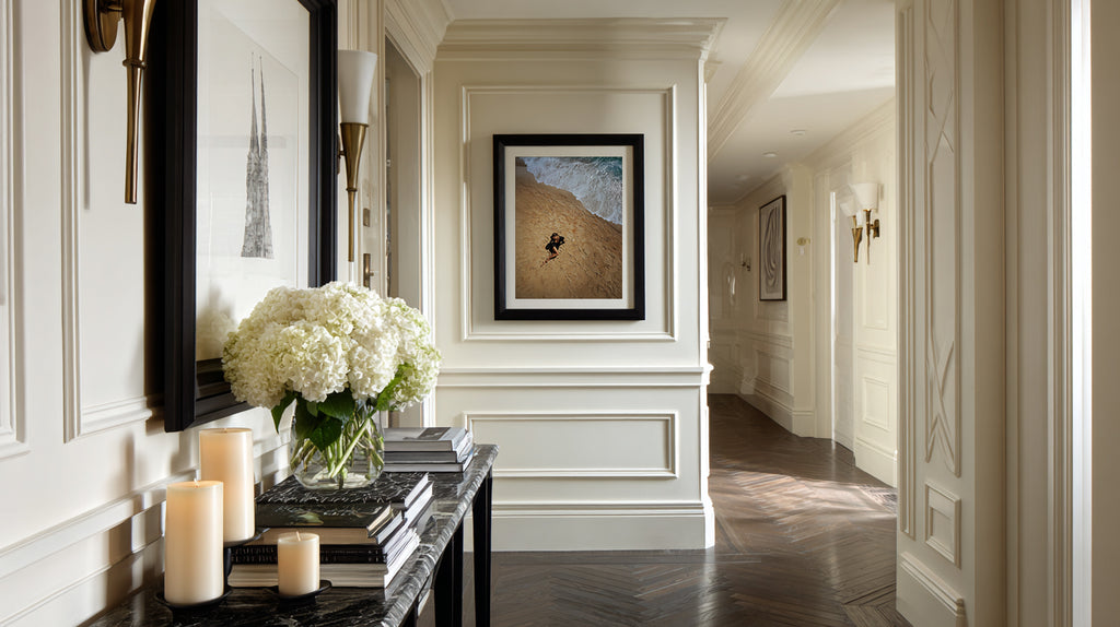 Elegant hallway with decorative elements including a mirror, candles, and framed artwork.