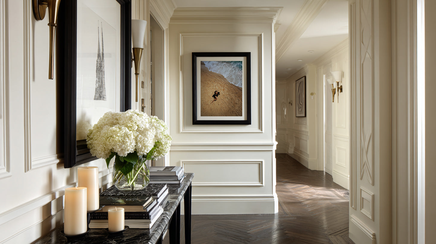 Elegant hallway with decorative elements including a mirror, candles, and framed artwork.