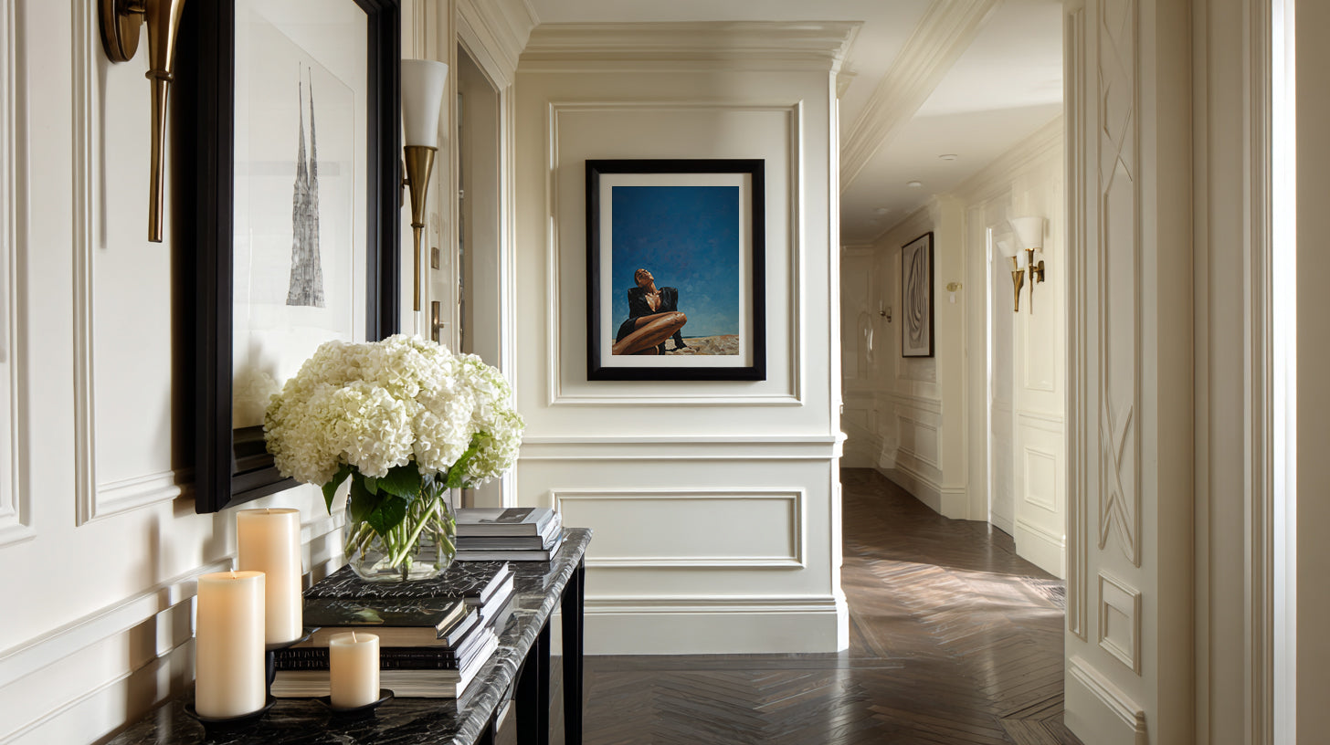 Elegant hallway with decorative elements including a mirror, candles, and framed artwork.