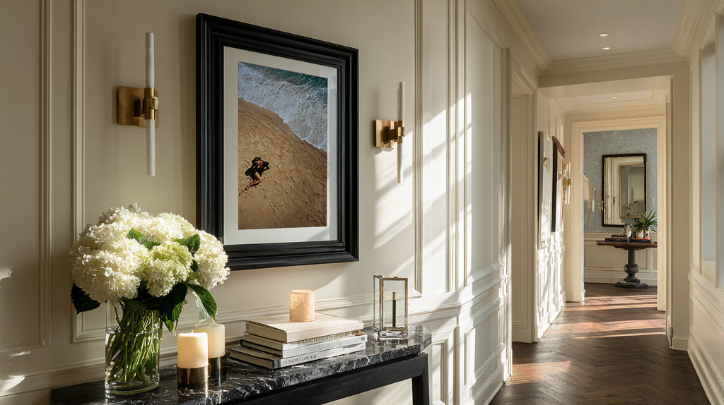 Elegant interior hallway with framed artwork, candles, and flowers.