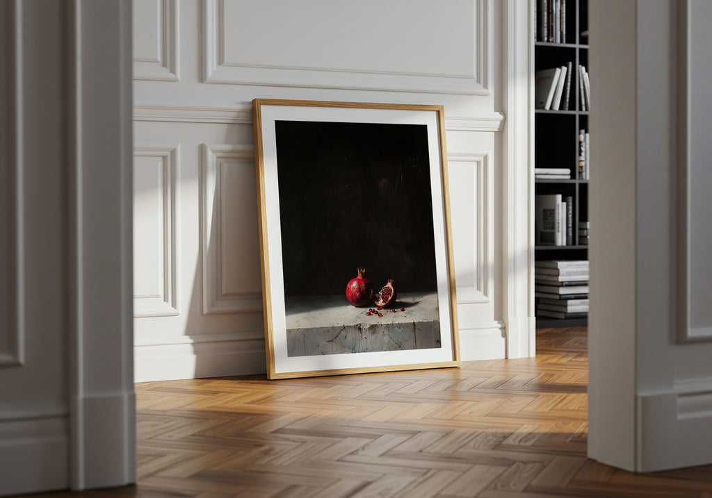 Framed artwork on a wall in a room with wooden flooring and a bookshelf.