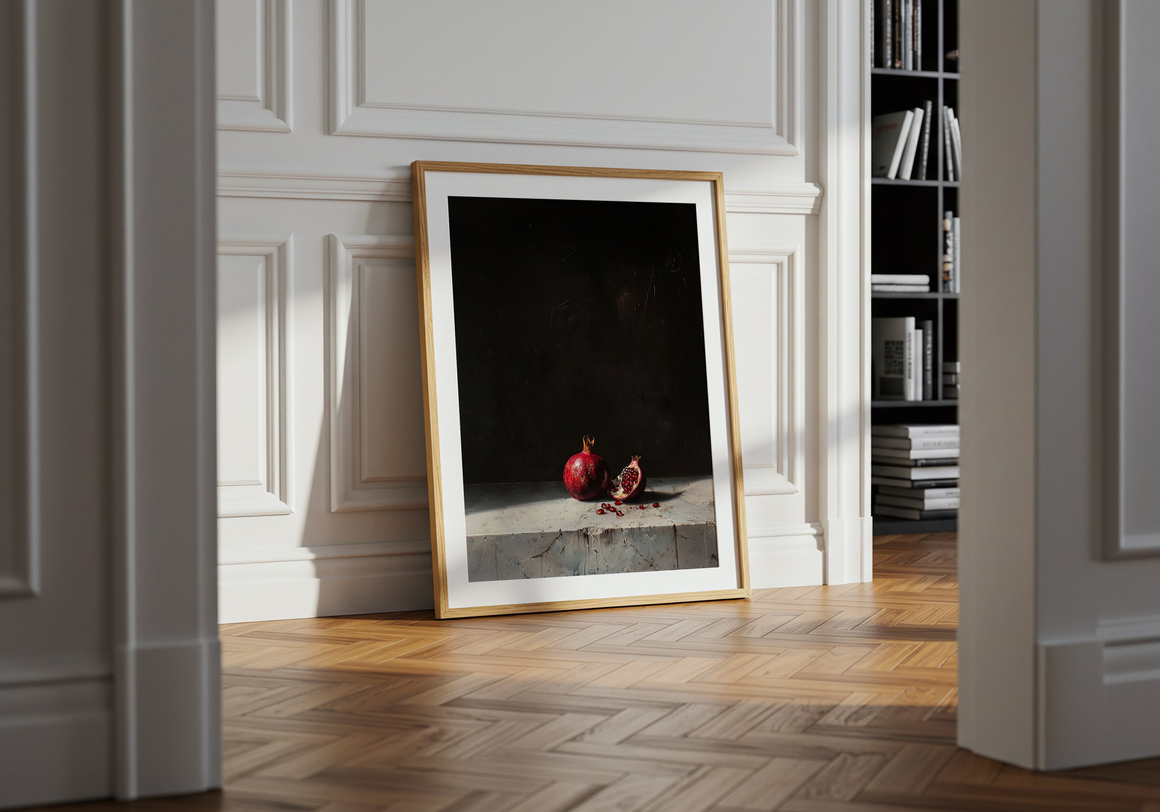 Framed artwork on a wall in a room with wooden flooring and a bookshelf.